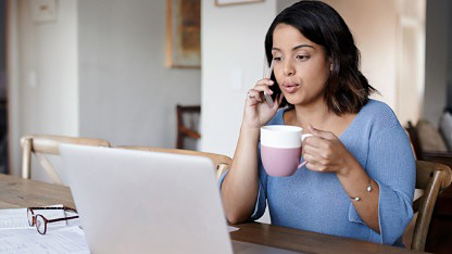 Lady drinking coffee and using laptop