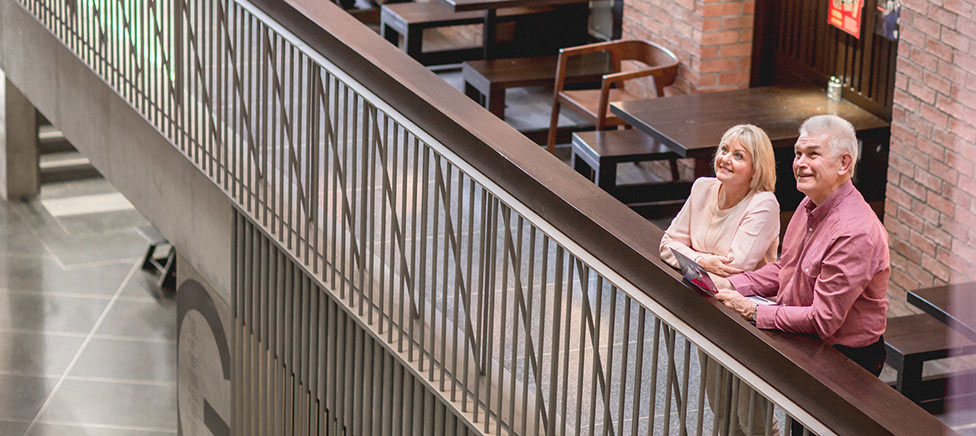 Mature man and lady relaxing in shopping centre