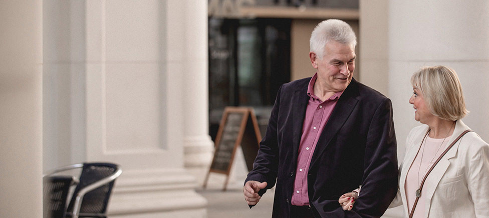 Mature man and lady relaxing in shopping centre