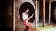 Woman on rattan pod chair using a tablet device