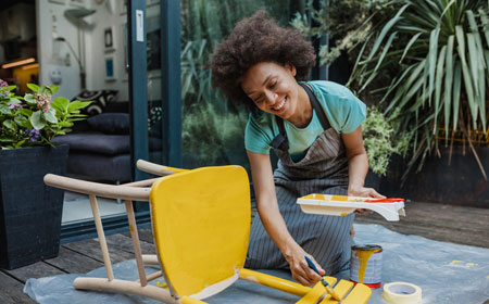 woman upcycling an old chair