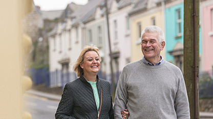 Happy mature couple walking down street